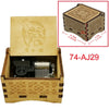 A wooden music box with an engraved bird design and a lid showing internal mechanisms.
