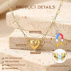 A gold plated heart pendant necklace is displayed on a light background with stacked blocks.