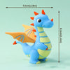 Una tierna figura de dinosaurio azul en forma de pastel con un pequeño dragón de alas naranjas y acentos amarillos.