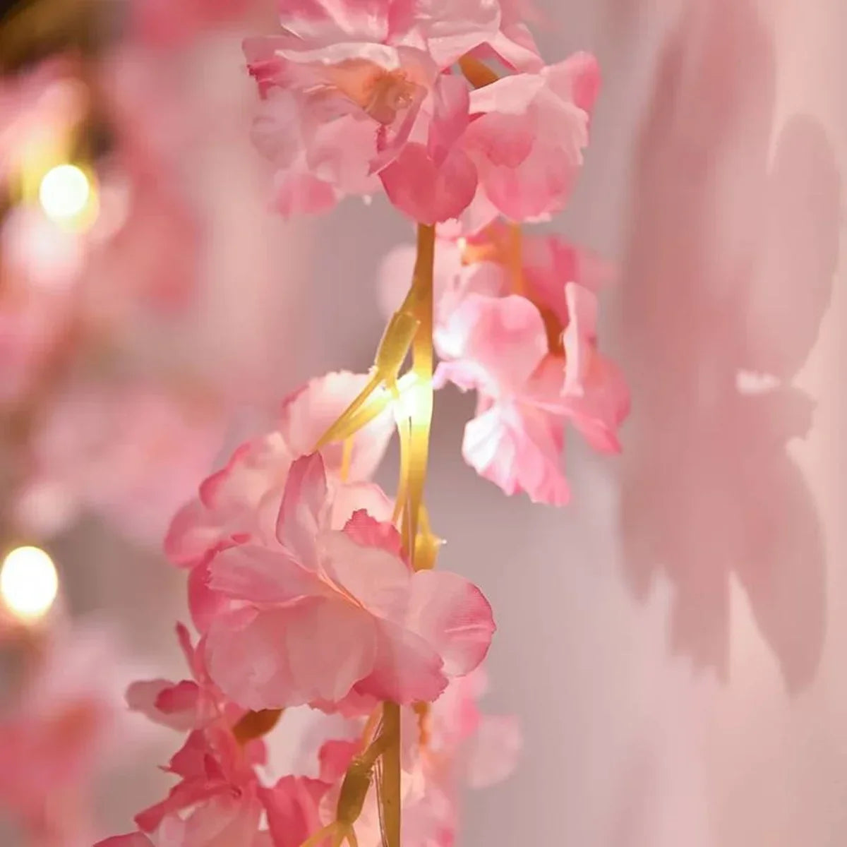 Close-up of pink cherry blossom string lights garland with soft bokeh background