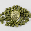 A pile of small, olive green wax sealing beads shaped like tiny cubes.