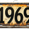 Letrero de aluminio vintage con el año 1969 grabado, mostrando signos de envejecimiento y pátina.