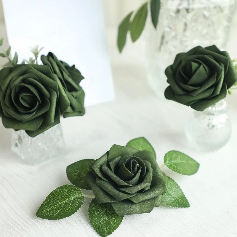 A close-up of forest green ombre foam roses with stems arranged on a white surface.