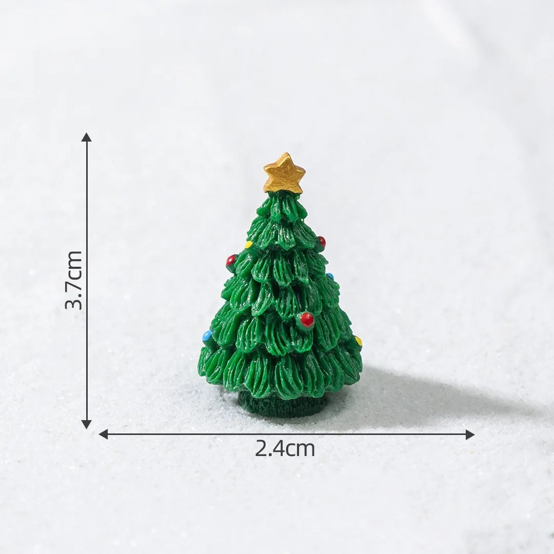 A small, green resin Christmas tree charm with a gold star topper resting on a white surface.