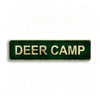 A rectangular, dark green metal tin sign with gold lettering that reads DEER CAMP.