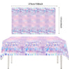 A table covered with a pink and purple patterned cloth featuring silhouettes of people celebrating a happy birthday theme.