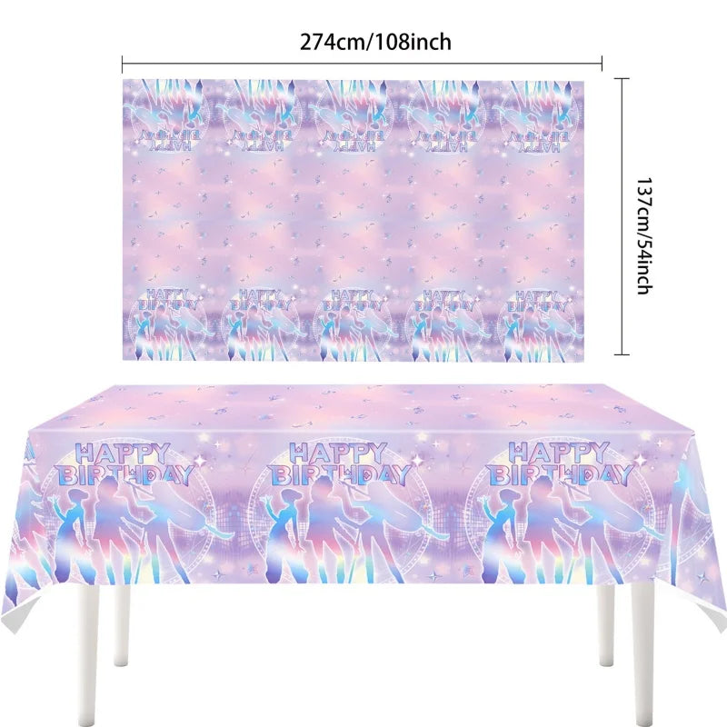 A table covered with a pink and purple patterned cloth featuring silhouettes of people celebrating a happy birthday theme.