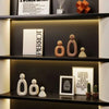 A display of modern resin family statues in various skin tones on dark shelves.