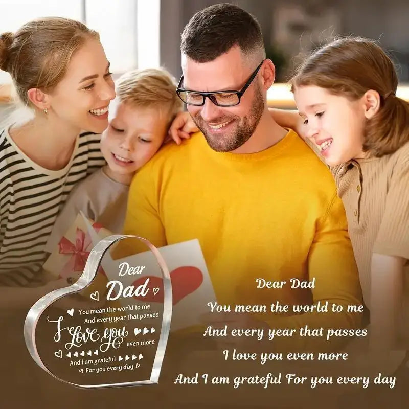 A family of four smiling together with a heart-shaped acrylic plaque for Dad