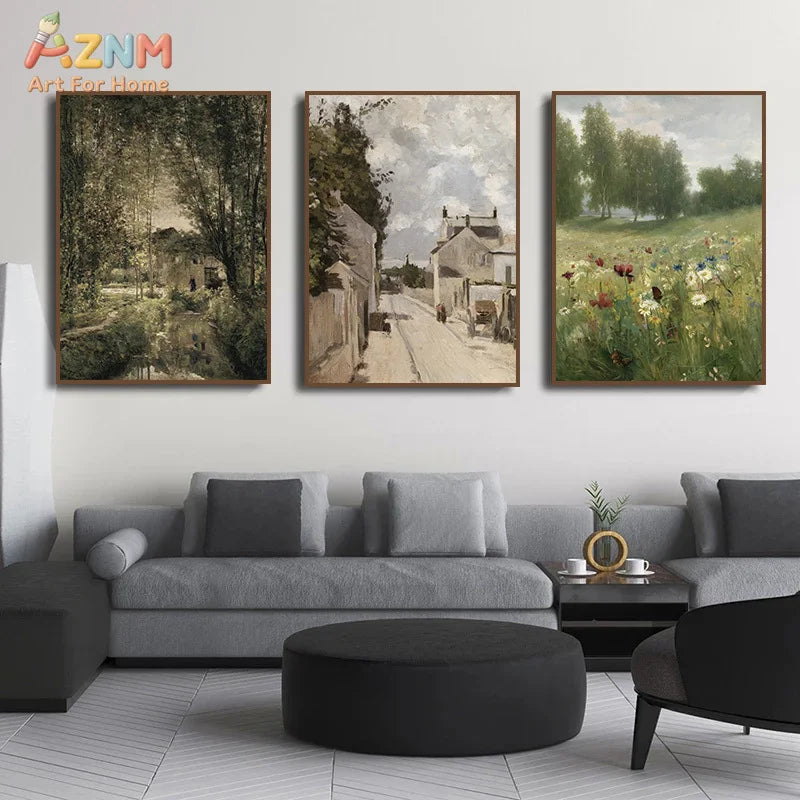 A set of three framed oil paintings depicting a vintage European countryside scene with a village and fields of wildflowers.