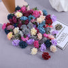 Un arrangement coloré de mini-fleurs d'hydrangea artificielles dans des tons de violet, rose, bleu et crème.