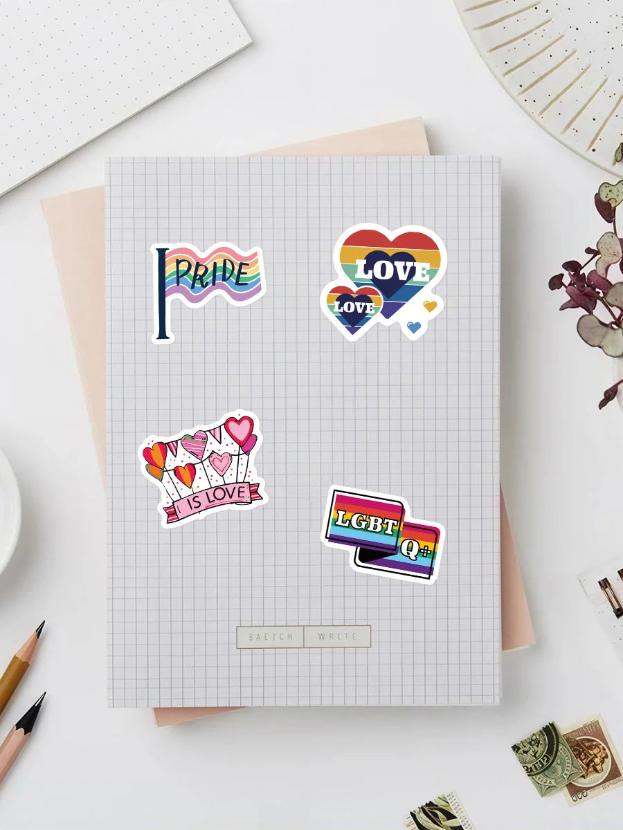 A sheet of graph paper features various colorful pride and love themed stickers including a pride flag, heart shapes, and LGB