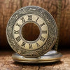 A vintage bronze quartz pocket watch with a decorative engraved face and chain resting on a wooden surface.