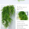 A long, green artificial ivy vine garland draped across a white surface.