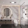 Baño moderno con tocador de mármol, espejo redondo y cabina de ducha de vidrio con iluminación vertical.