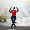A red-shirted figure with black pants stands on a snowy surface, raising both arms in a pose.