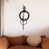 Schwarze minimalistische geometrische Wandskulptur mit konzentrischen Kreisen und vertikalen Linien an einer weißen Wand.
