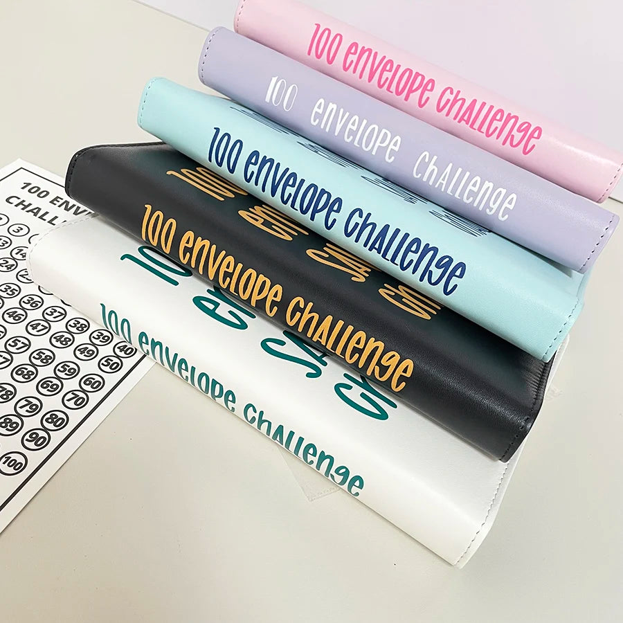 A stack of five colorful A5 binders for a 100 envelope savings challenge with numbered pockets