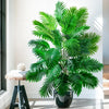 A vibrant artificial palm tree with lush green silk leaves displayed in a black pot.