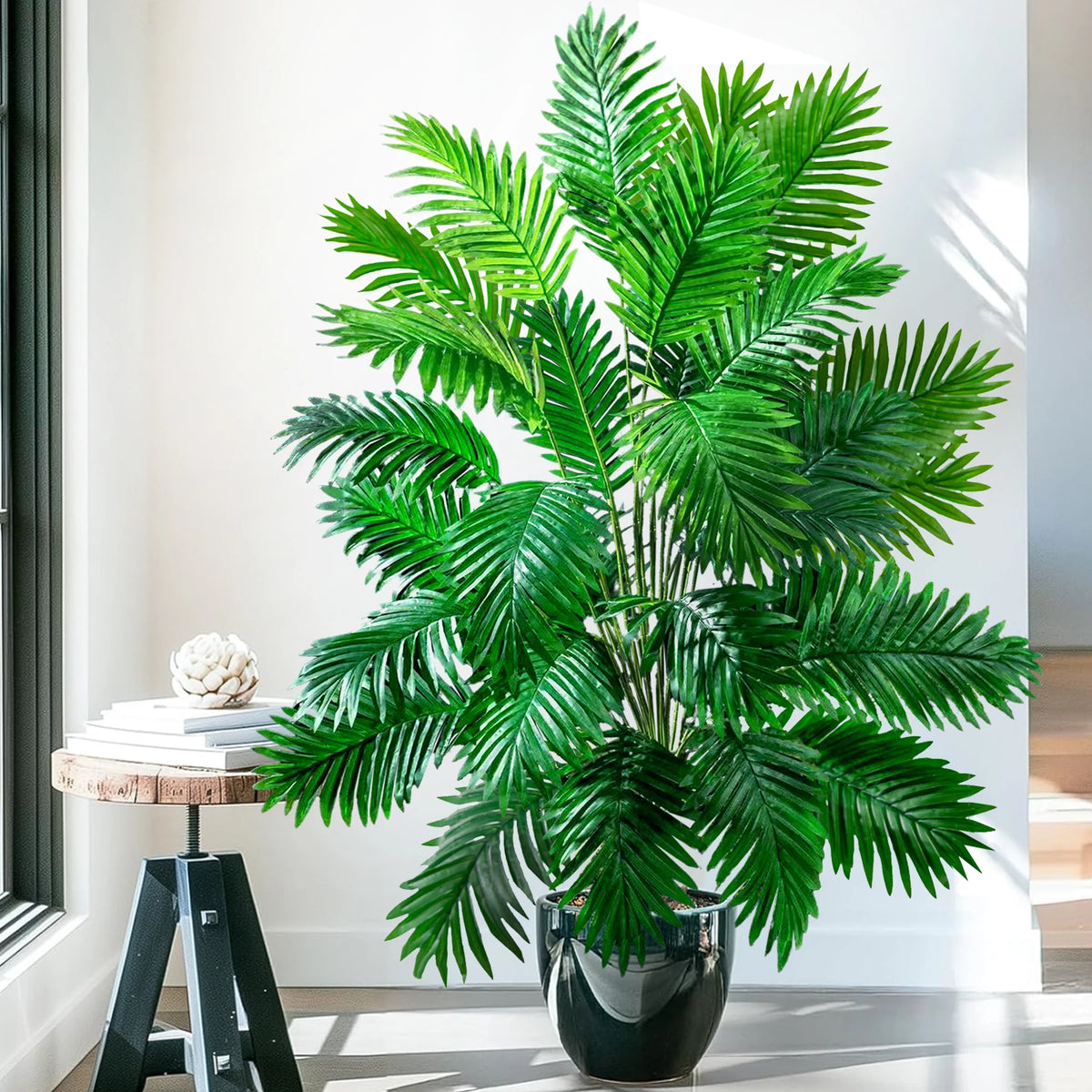 A vibrant artificial palm tree with lush green silk leaves displayed in a black pot.