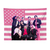 A pink American flag tapestry featuring seven Kpop idols standing against a striped background.