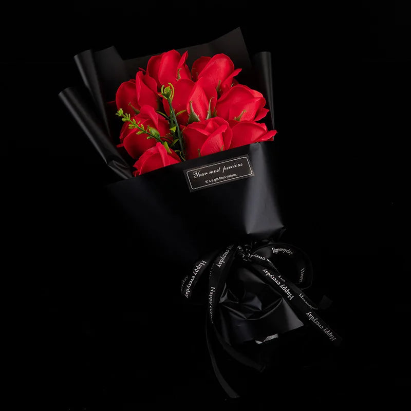 A bouquet of red roses presented in black paper with a black ribbon.
