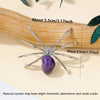 A handcrafted crystal spider figurine resting on a wooden surface with dimension markings.
