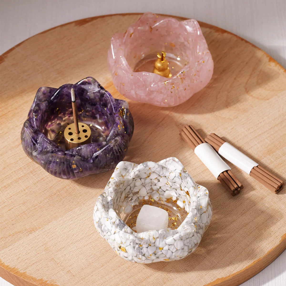 A set of natural crystal droppers in pink and purple glass are displayed on a wooden surface.