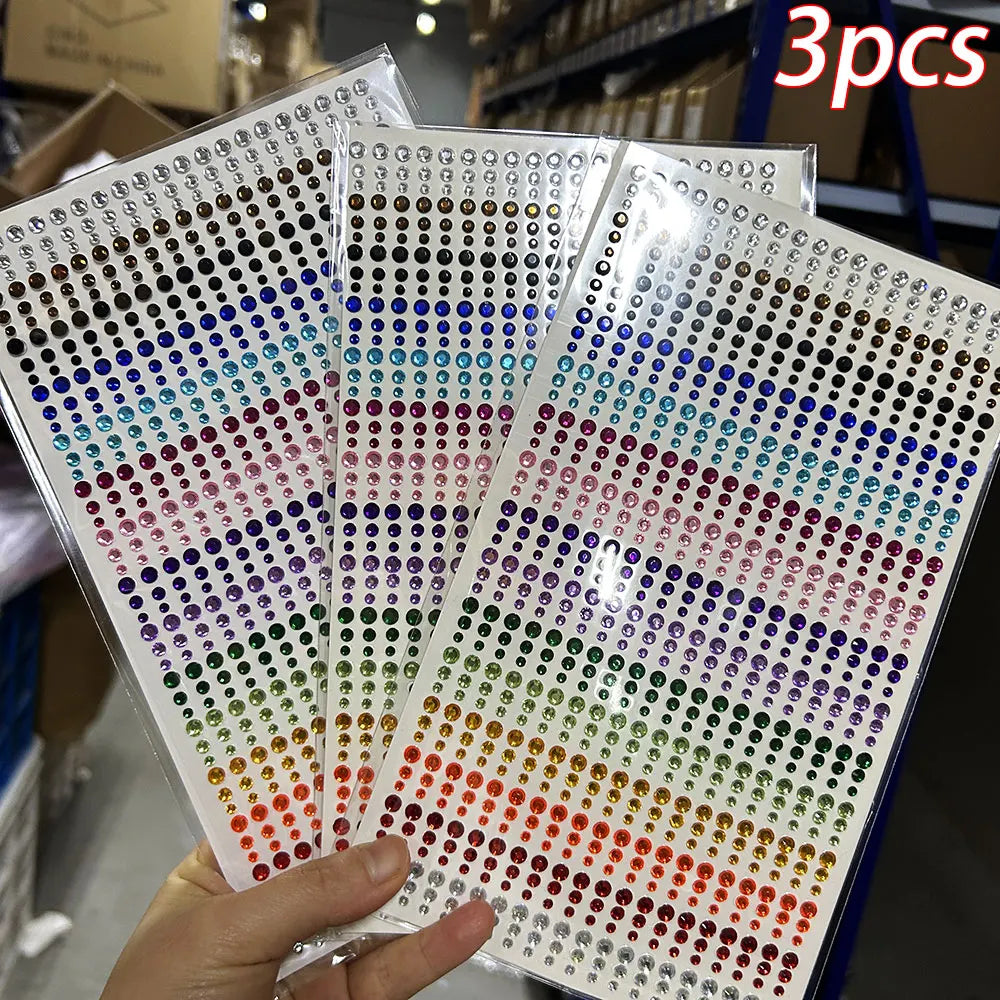 A hand holds a sheet of glitter gem stick-on facial tattoos showing various colors arranged in rows.