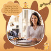 A smiling woman in a light top sits at a desk with a crocheted Highland cow keychain beside her.