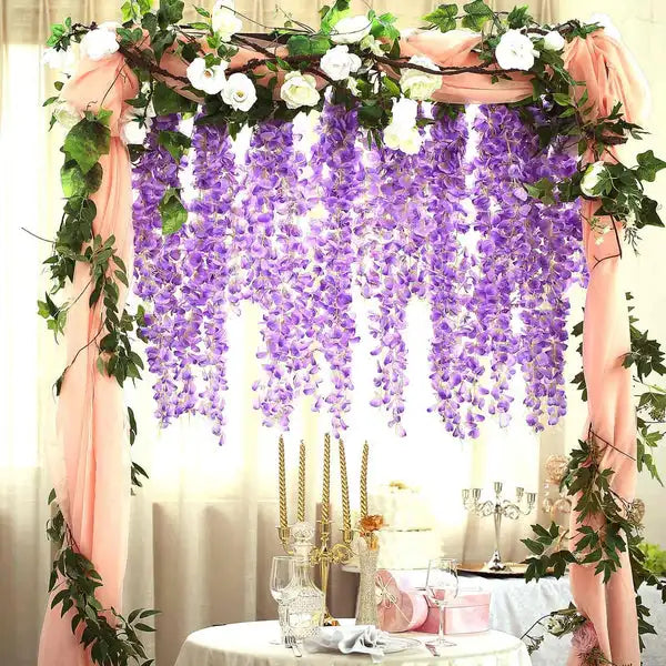 Arche florale décorée de draperies roses et de guirlandes de wisteria artificielle violette.