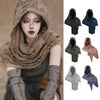 A model wearing a textured, earth-toned hooded cloak with fringe details and a Viking brooch.