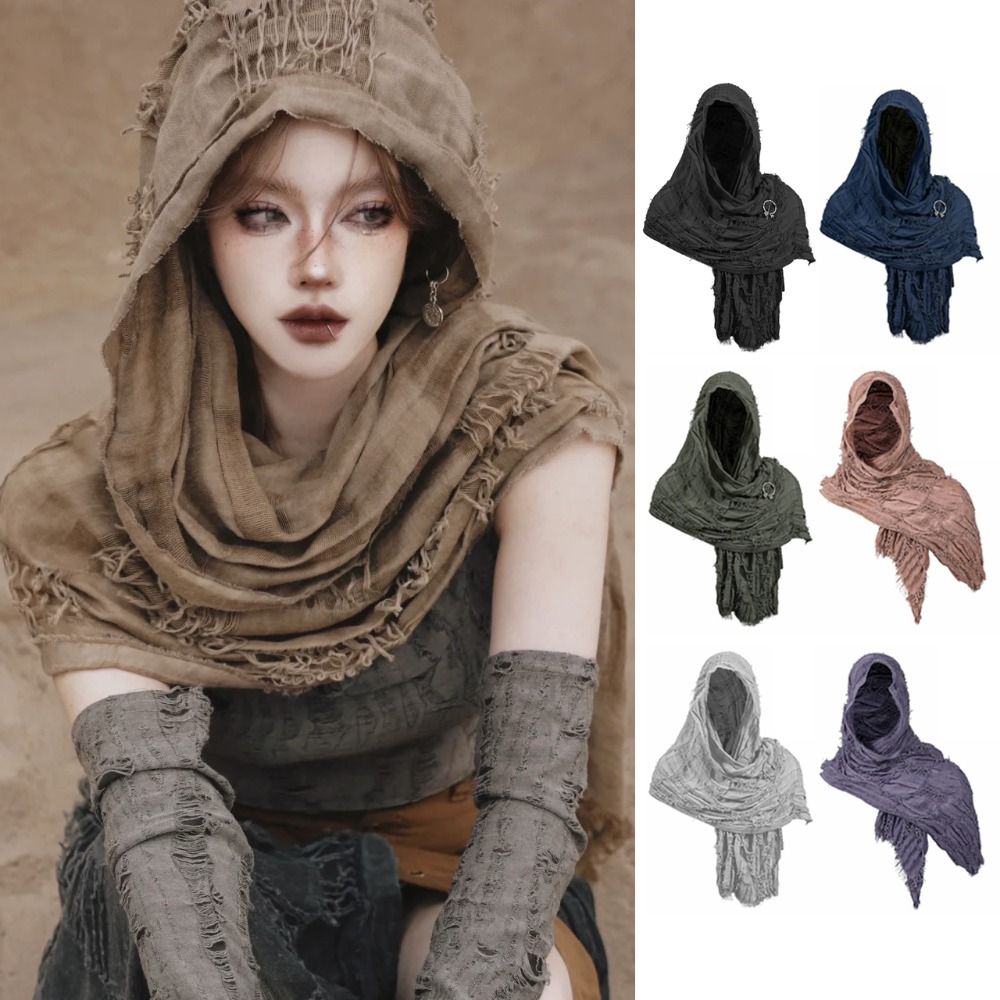 A model wearing a textured, earth-toned hooded cloak with fringe details and a Viking brooch.